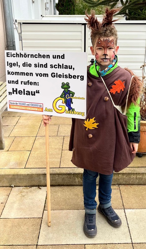 Kind im Eichhörnchen-Kostüm mit Gleisbergschule-Schild